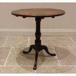 A George III oak tilt top tripod table, the circular plank top upon a baluster pedestal extending to