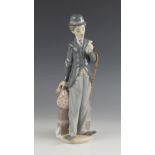 A Lladro figure modelled as Charlie Chaplin, late 20th century, modelled standing with a bundle