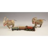 Two clockwork donkeys, mid 20th century, each modelled standing with applied insect, each 11cm long,
