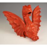 A cast iron red painted decorative bracket modelled as a winged dragon, 30cm wide