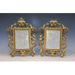A pair of Rococo style gold painted cast metal mirrors, early 20th century, each with folding stand,