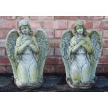 A pair of reconstituted stone garden ornaments, modelled as kneeling angels with arms crossed,