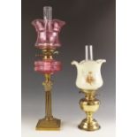 A Victorian cranberry glass oil lamp, mid 19th century, the reeded brass column with Corinthian