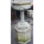 A reconstituted stone garden urn, of bowl form, cast in relief with swags upon a fluted column, 70cm