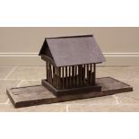 A Folk Art bird house, with a slate roof upon alternating half and full length spindles, to a