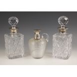 A pair of silver collared decanters, London 1979, the rectangular glass body with canted corners and
