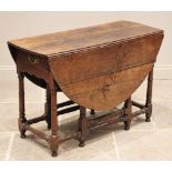 A late 17th century oak gate leg table, the oval plank top above a single frieze drawer, upon ring