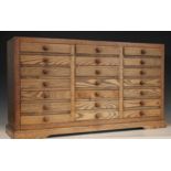 An oak specimen cabinet, 20th century, formed from three banks of seven small drawers, applied