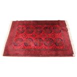 A modern Bokhara pattern rug, the ten octagonal medallions upon a deep red ground, 195cm x 138cm