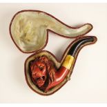 A carved 'meerschaum' style pipe, 19th century, the pipe mounted with a carved head of a lion with