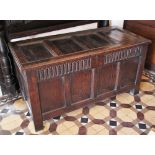 * A 17th century oak coffer, the hinged cover with four inverted panels opening to a fitted candle