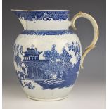 A pearlware blue and white jug of large proportions, early 19th century, of ovoid form with raised