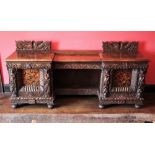 * A 19th century carved oak sideboard, probably Flemish, of inverted breakfront form, the carved