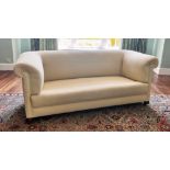 * A Victorian Chesterfield type settee, of typical deep set form, with padded scrolled arms and back