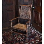 * An 18th century oak and bergère open armchair, the rattan panel back flanked by barley twist