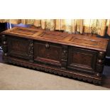 * A 17th century oak and marquetry cassone/coffer, the hinged three panel top above three