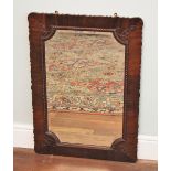 * A mahogany framed wall mirror, early 20th century, the rectangular frame with a wavy shaped edge
