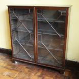 * A 19th century mahogany glazed bookcase, the rectangular moulded top over a pair of astragal