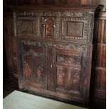* A 17th century and later carved oak court cupboard, of joined construction, the moulded cornice