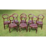 * A set of nine Victorian mahogany balloon back dining chairs, the crest rail centred with a