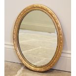 * A 19th century style oval gilt framed wall mirror, 20th century, the mirrored plate within a mould