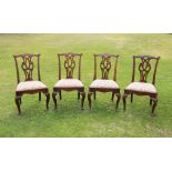 * A set of four George II mahogany dining chairs, each chair with a cupids bow top rail extending to