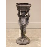 A figural lead planter, modelled as a putti holding a basket aloft, upon a naturalistic rocky