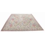 A wool carpet, in red, blue, green and yellow colourways, with an all over floral lattice pattern,