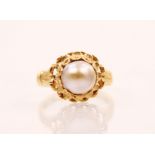 A cultured pearl and yellow metal ring, the central baroque shaped pearl set within an openwork