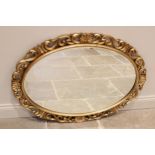 A gilt composite Florentine oval wall mirror, late 20th century, the scrolling openwork frame