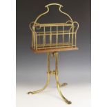 A late 19th century oak and brass revolving magazine rack / Canterbury, raised on three swept