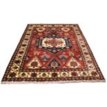 A Caucasian design wool rug, in oxidized red, blue, ivory and green colourways, the central