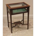 An Edwardian mahogany and satinwood banded bijouterie table, the hinged bevelled glass cover opening