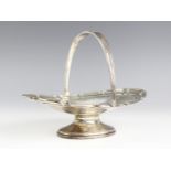 A George V silver swing handled bonbon dish, Harrods Stores Ltd, London 1913, of oval form with