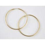 A pair of hollow yellow metal hoop earrings, the plain polished hoops with post fitting, stamped '