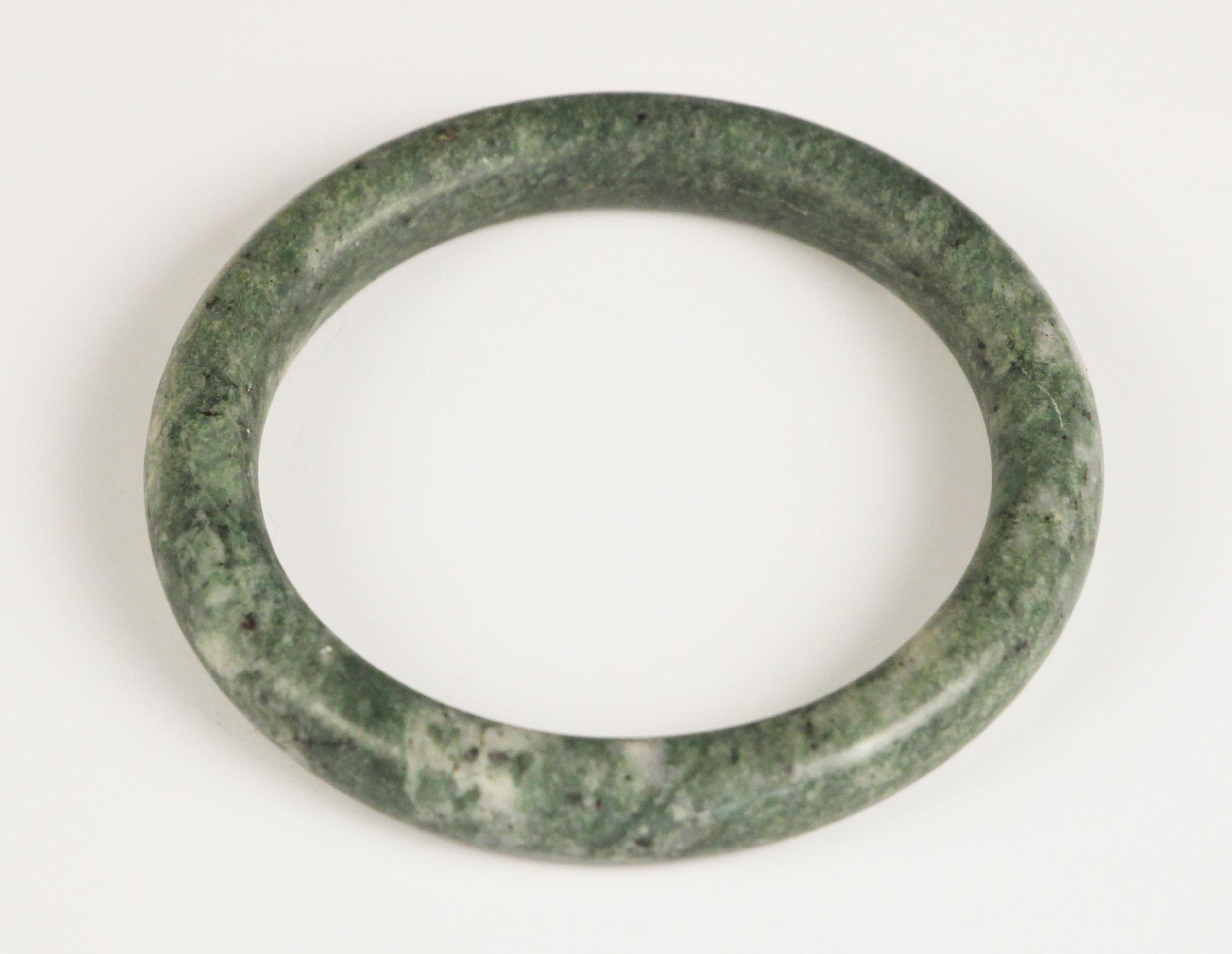 A Chinese polished Jade bangle, of plain polished spherical form, 7.5cm wide overall
