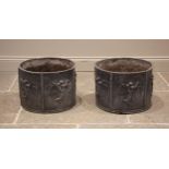 A pair of cylindrical lead planters, formed with six panels each cast in relief with winged