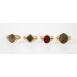 A 9ct yellow gold and red stone set signet ring, the oval set stone within plain polished mount