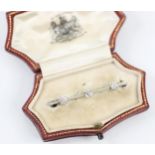 An early 20th century diamond bar brooch, the three old cut diamonds claw set within a white metal