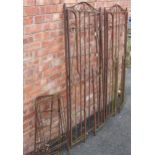 A pair of wrought iron folding garden arbours, with open scroll work side panels, each measures