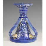 A faience candlestick, 20th century, decorated with a blue and white foliate and fence design, the