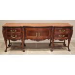 An Italian carved walnut sideboard, mid 20th century, the serpentine break-front above central