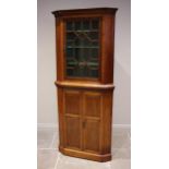 An Edwardian walnut freestanding corner display cabinet, the moulded cornice over an astragal glazed