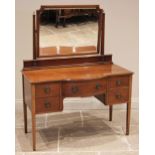 An Edwardian mahogany dressing table, of break-arch form, the bevelled mirror plate above an