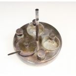 A stainless steel cruet set, the circular base with five bottle cruet including salt, pepperette,