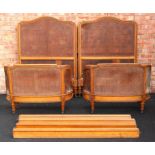 A pair of French walnut bergère single beds, late 19th/early 20th century,