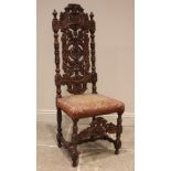 A carved walnut Carolean style hall chair, 19th century, the carved foliate and 'C' scroll high back