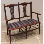 An Edwardian mahogany upholstered two-seater hall/parlour chair, the twin pierced splats above a