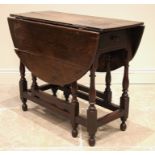 An 18th century oak gateleg table, the oval plank top over a single frieze drawer, upon slender