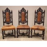 Three Carolean style oak and tan leather hall chairs, late 19th century, each with an arched